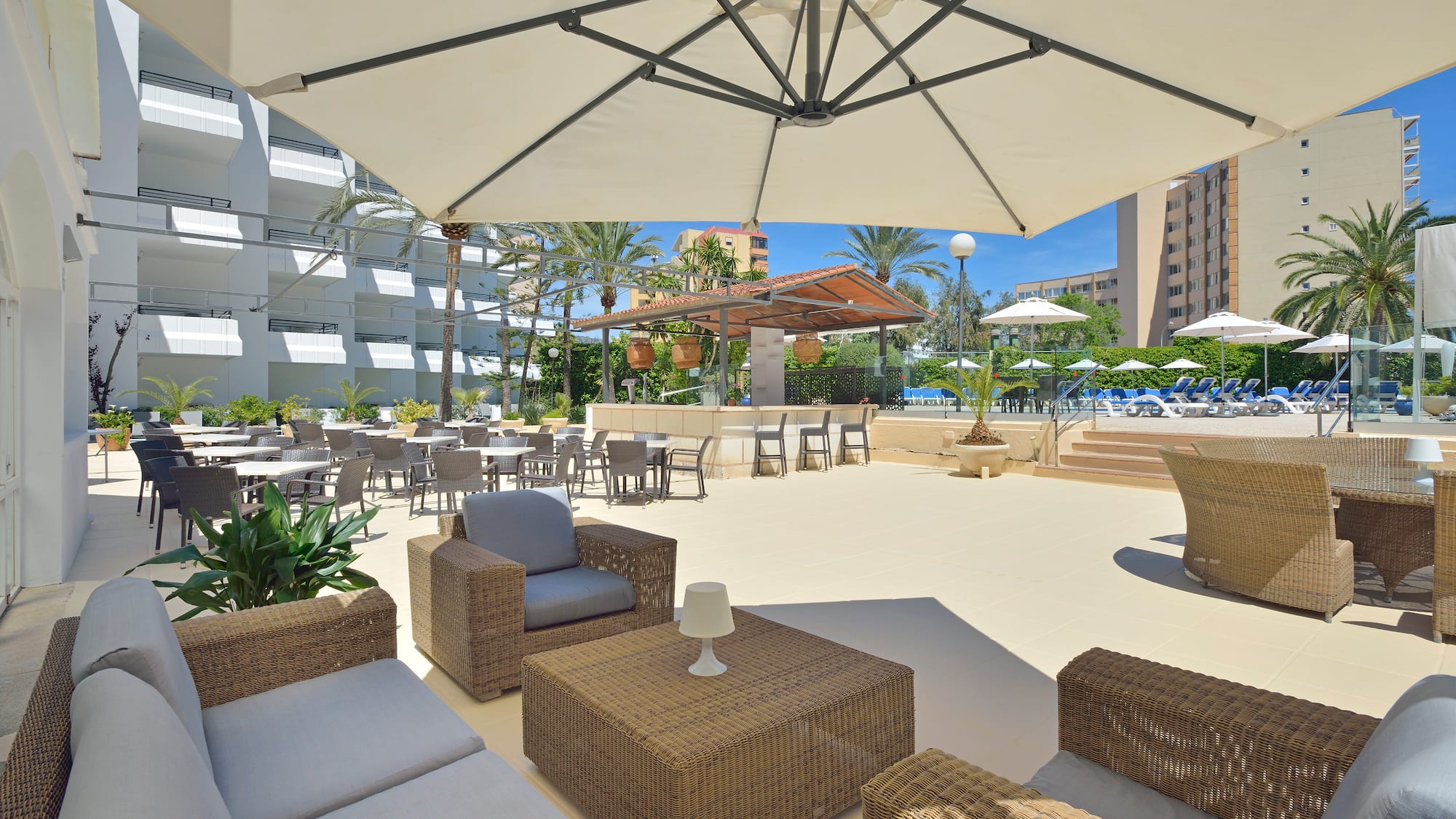 a patio area with chairs and tables and umbrellas