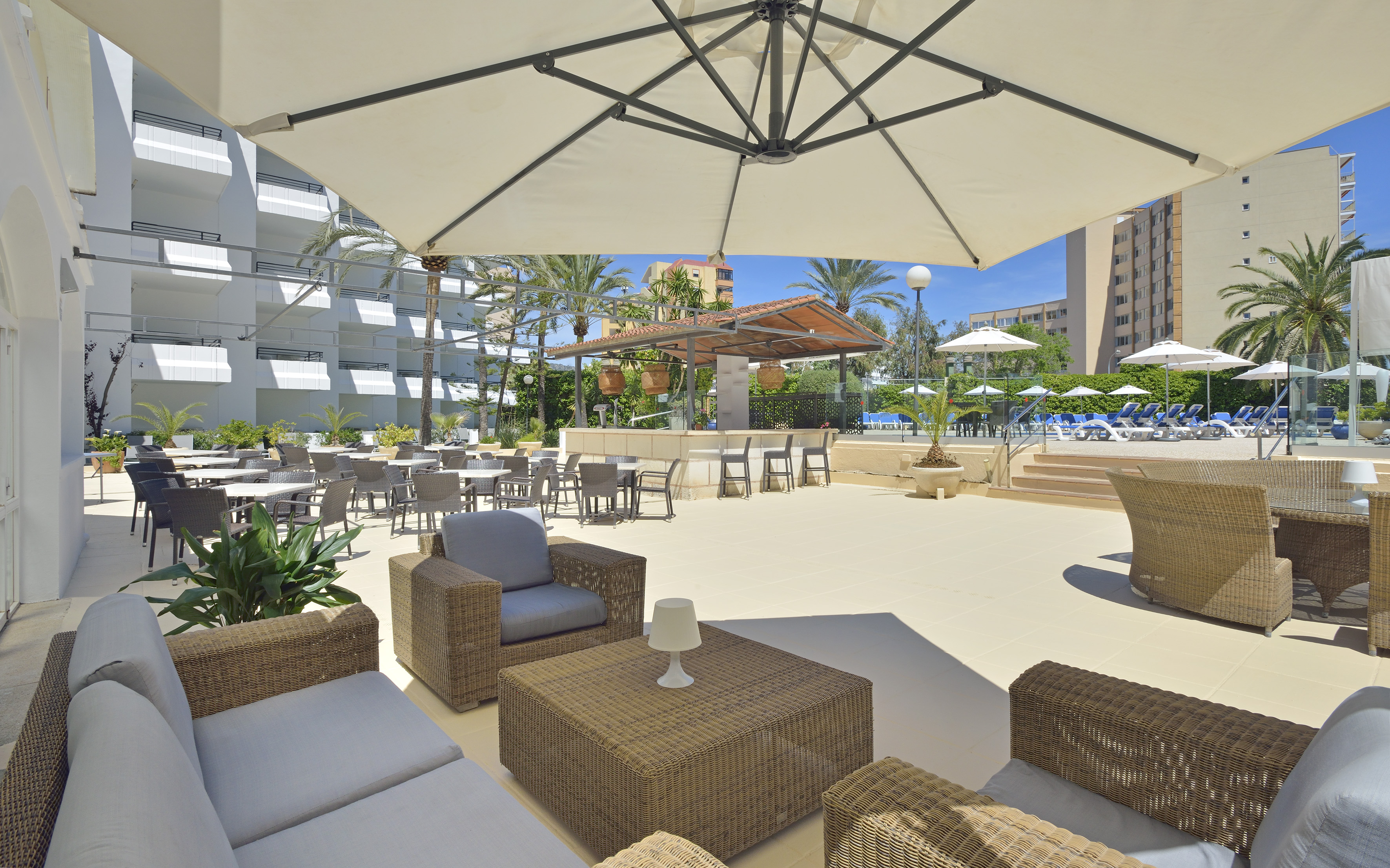 a patio area with chairs and tables and umbrellas