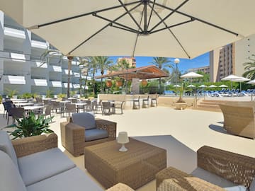 a patio area with chairs and tables and umbrellas