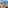Hotel balcony with ocean view, beach, tropical pools, and palm trees.