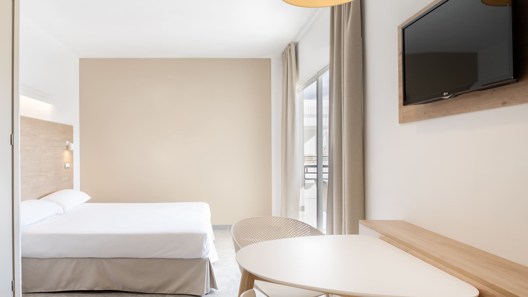 a room with a bed and a table and a television