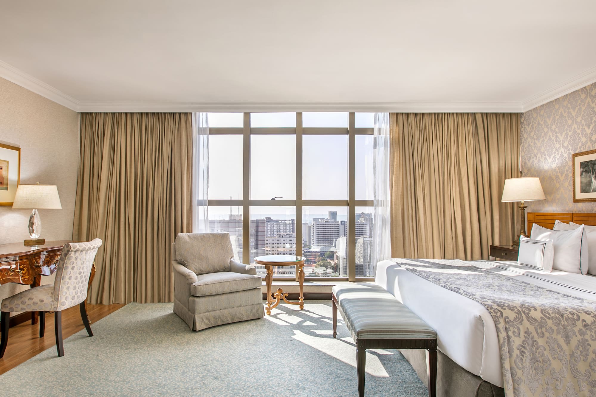 a room with a bed and chairs and a table