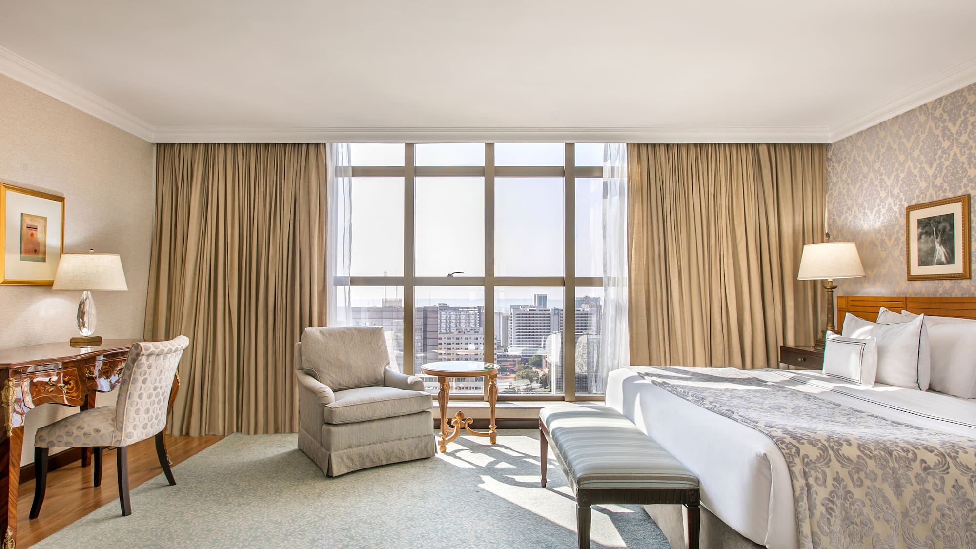 a room with a bed and chairs and a table