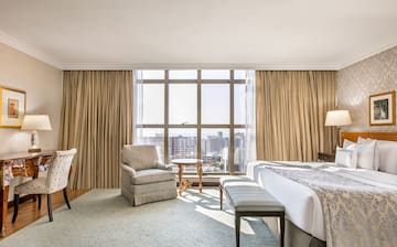 a room with a bed and chairs and a table