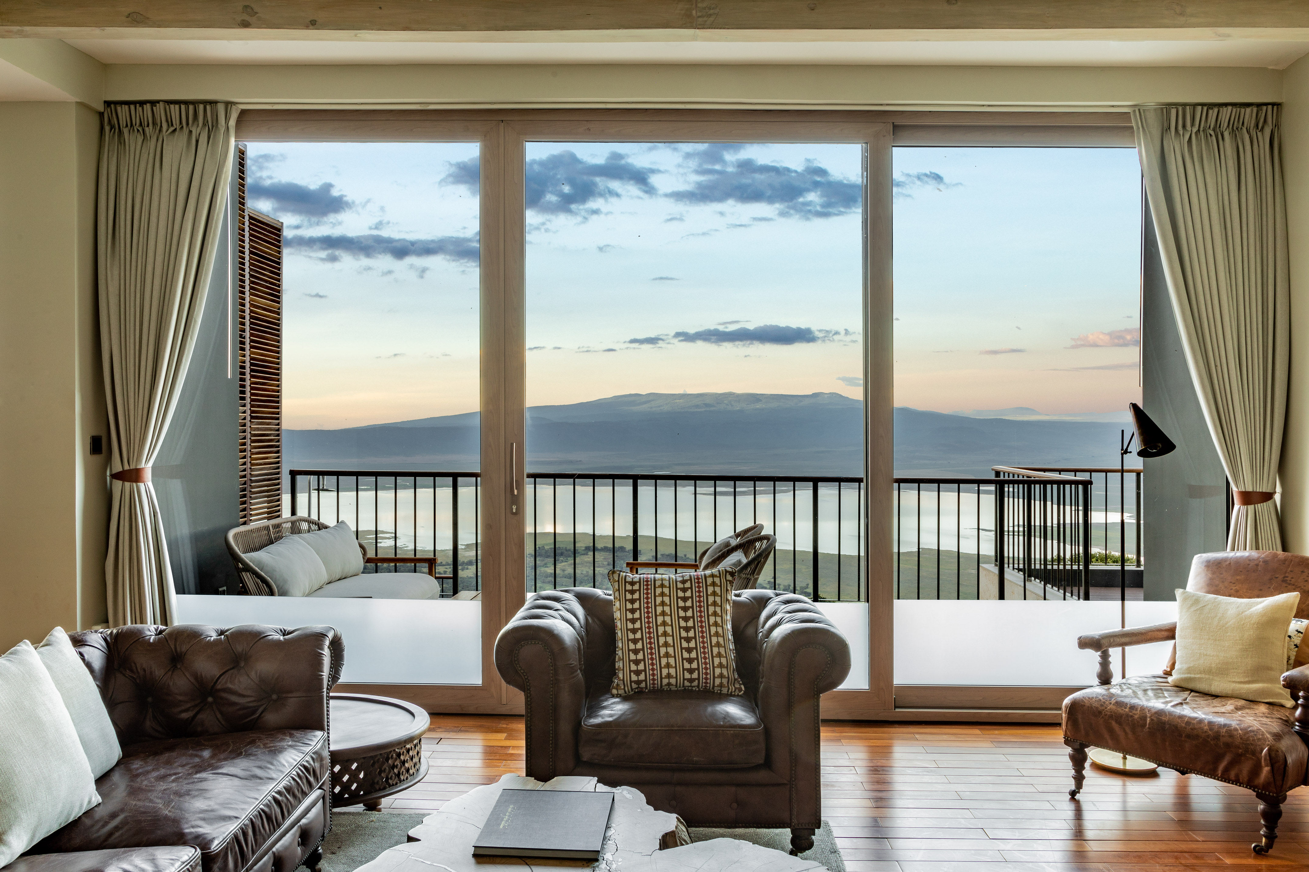 Luxury living room with panoramic mountain and lake views from balcony.