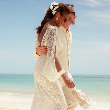 a man and woman walking on a beach
