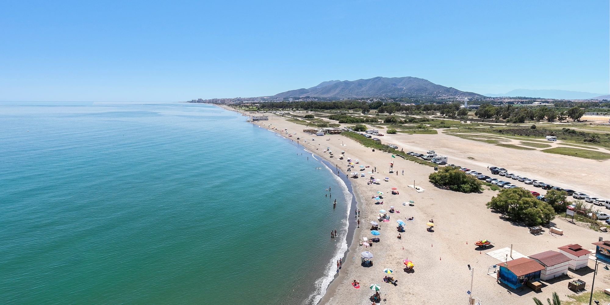 a beach with many umbrellas and people on it