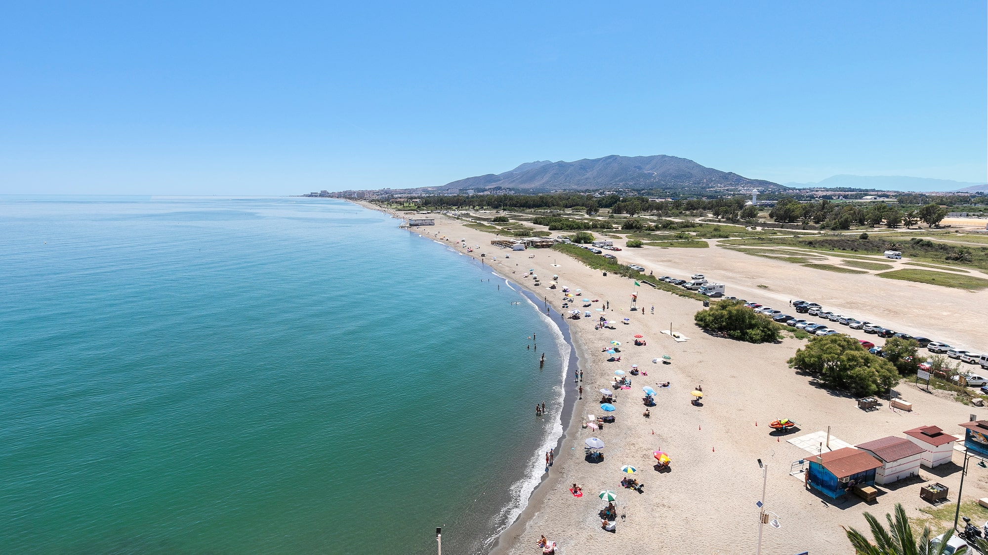 a beach with many umbrellas and people on it