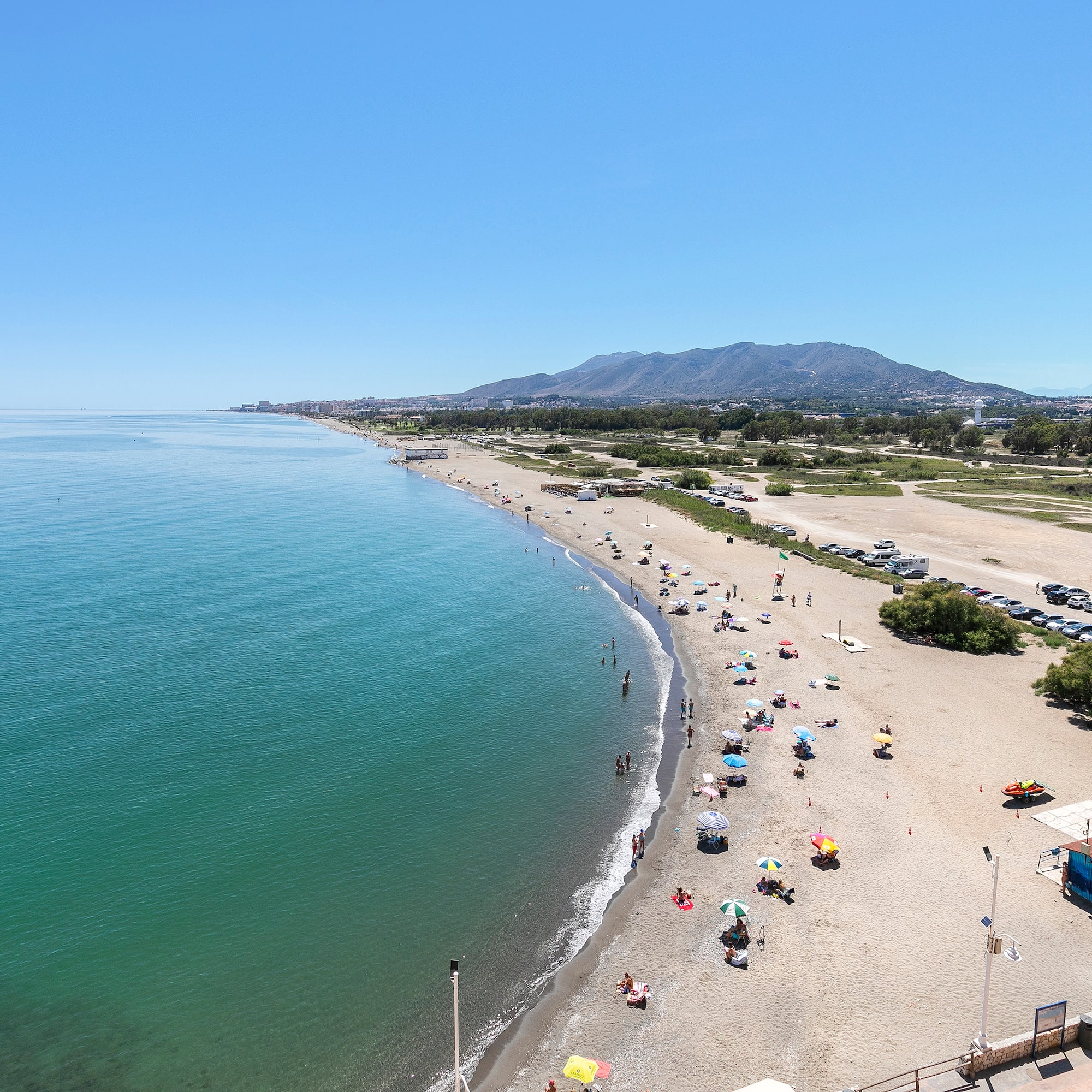 a beach with many umbrellas and people on it