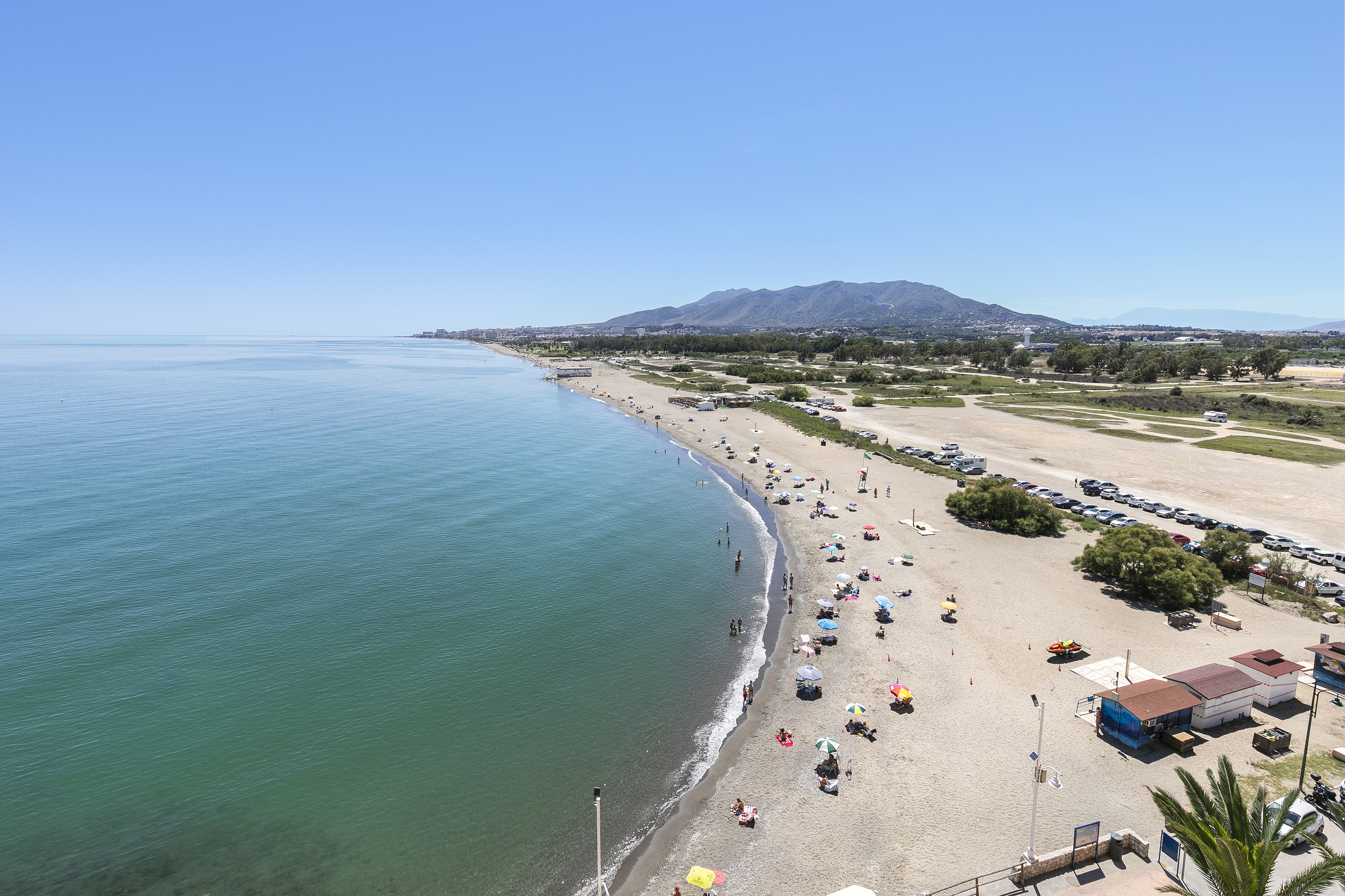 a beach with many umbrellas and people on it