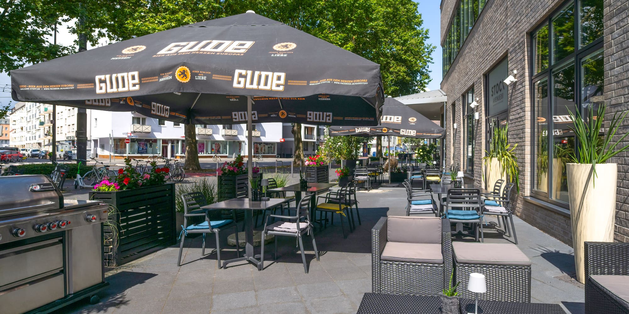 a patio with tables and chairs under an umbrella
