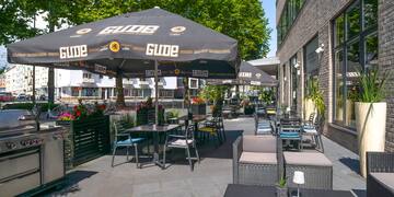 a patio with tables and chairs under an umbrella