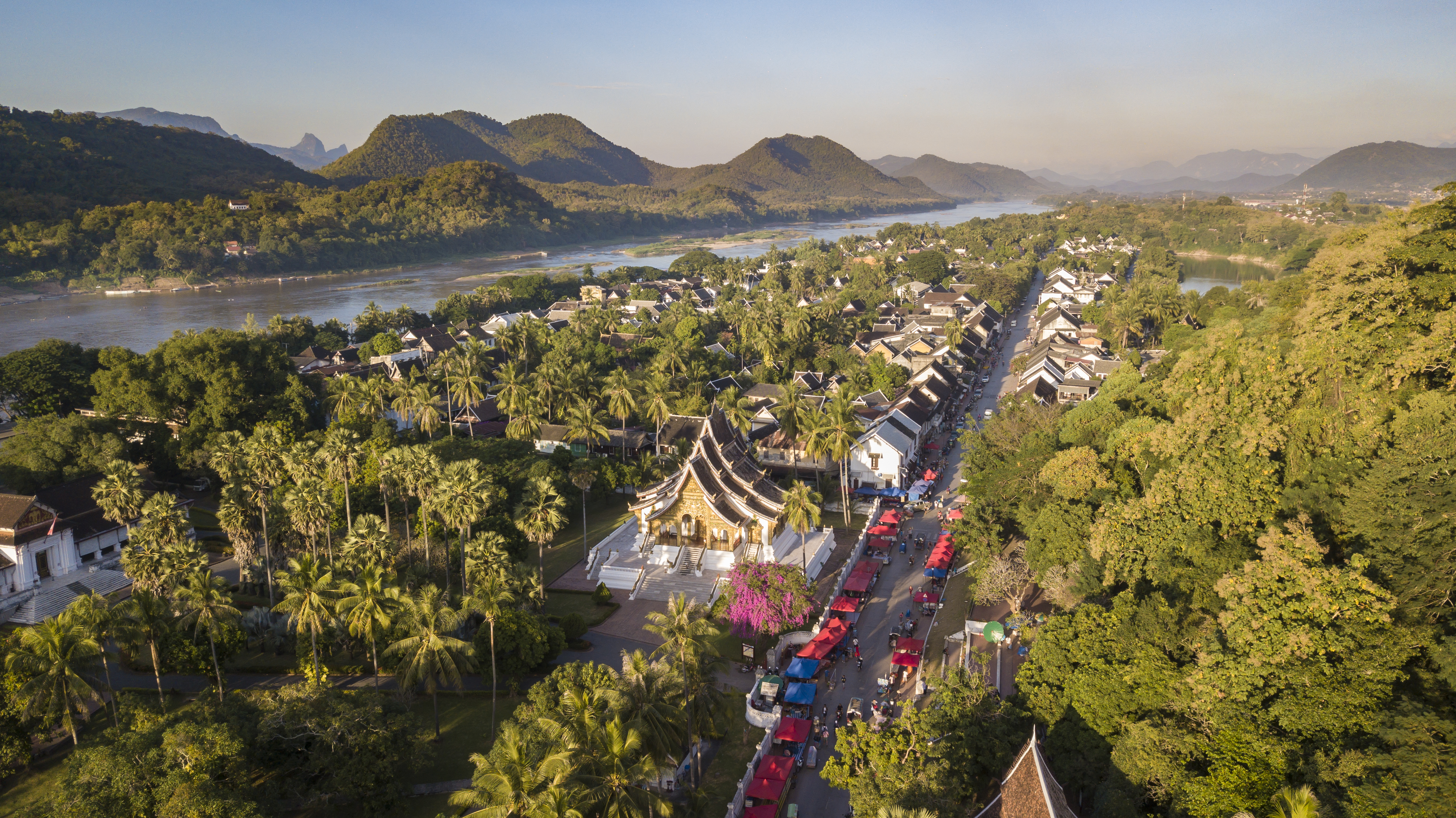 Aerial view of Luang Prabang with temple, market street, and Mekong River.