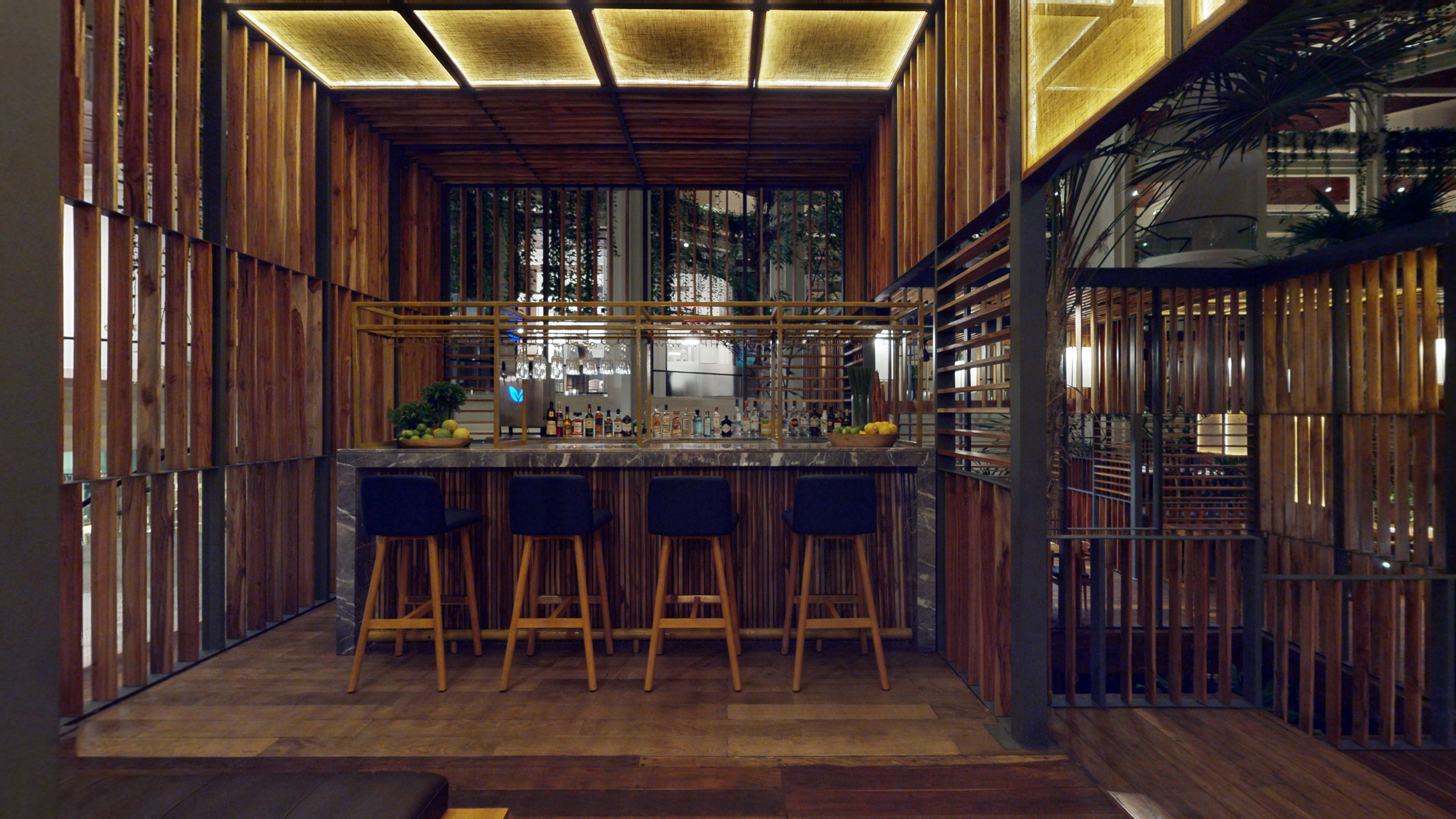a bar with stools and a bar in a room