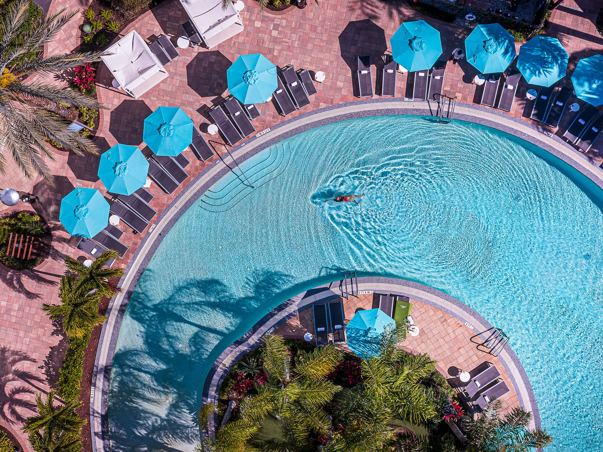 a swimming pool with umbrellas and chairs