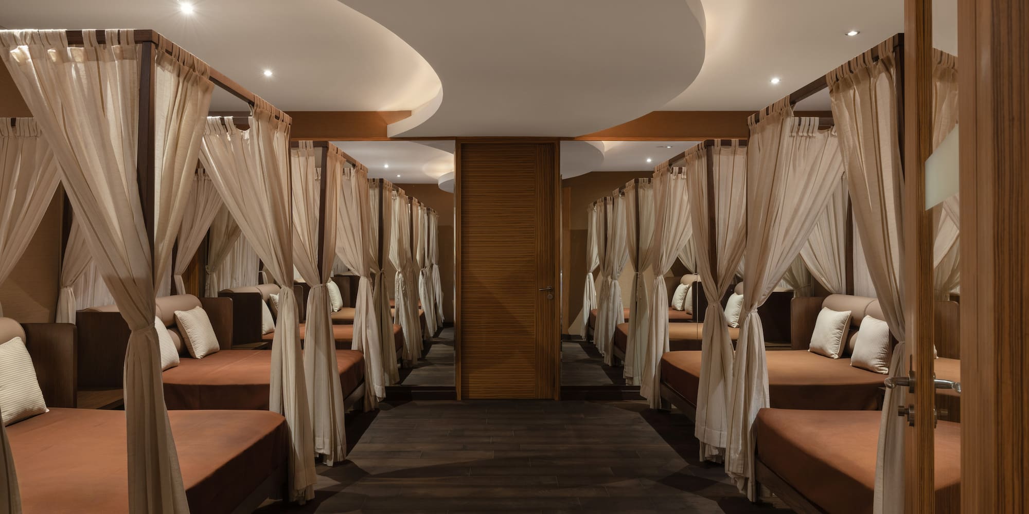 a room with many beds and curtains