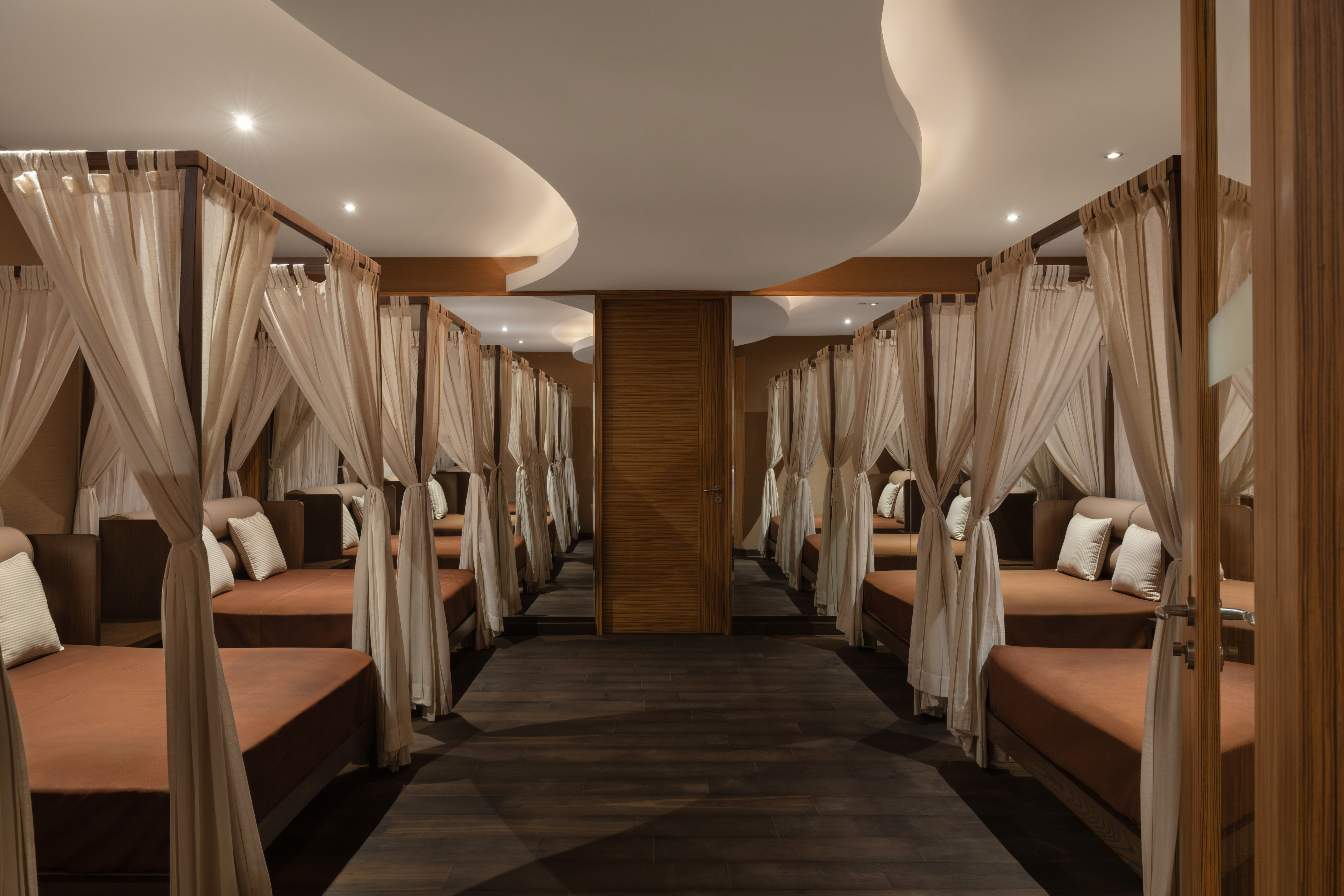 a room with many beds and curtains