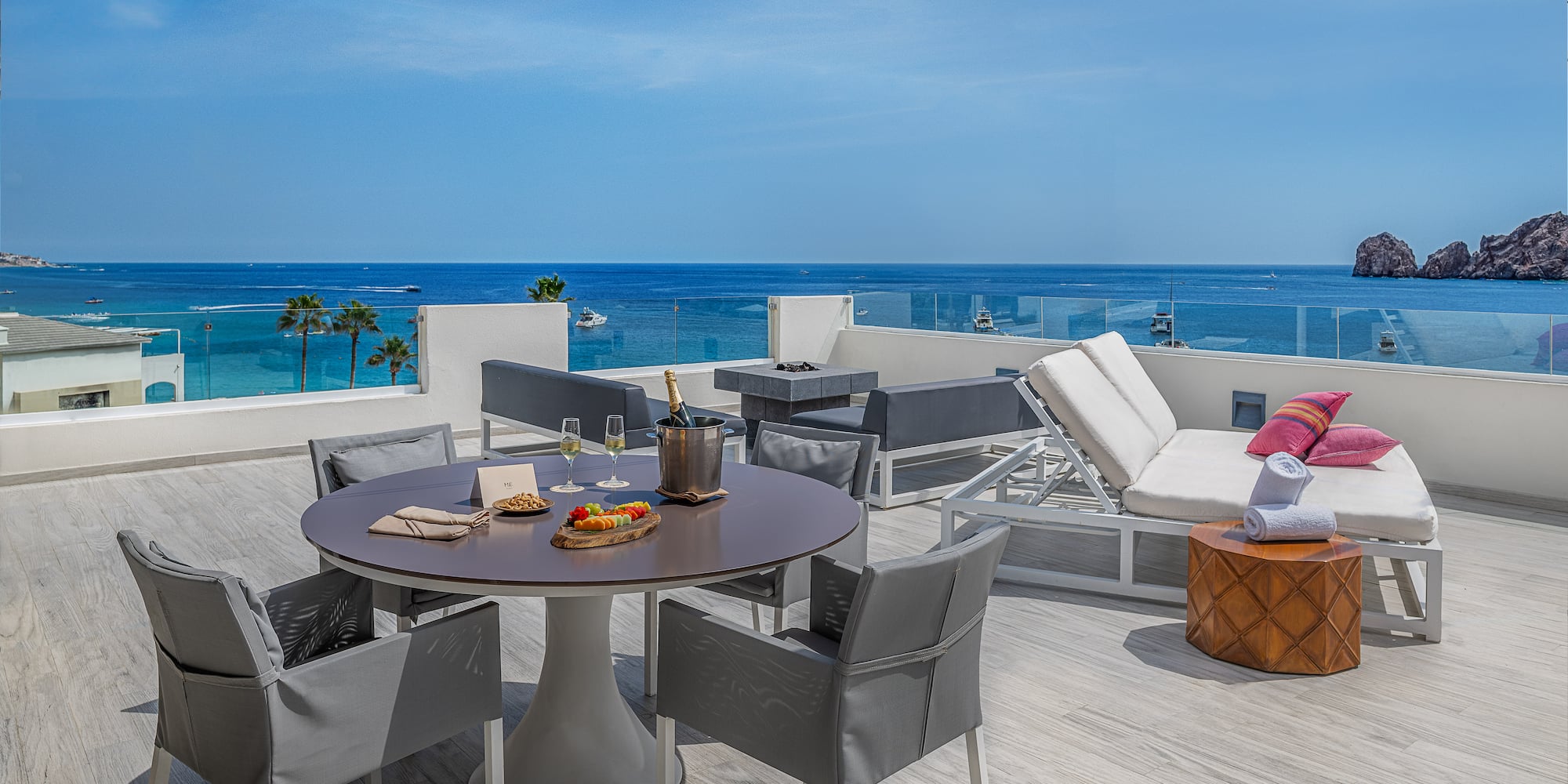 a table and chairs on a deck overlooking the ocean