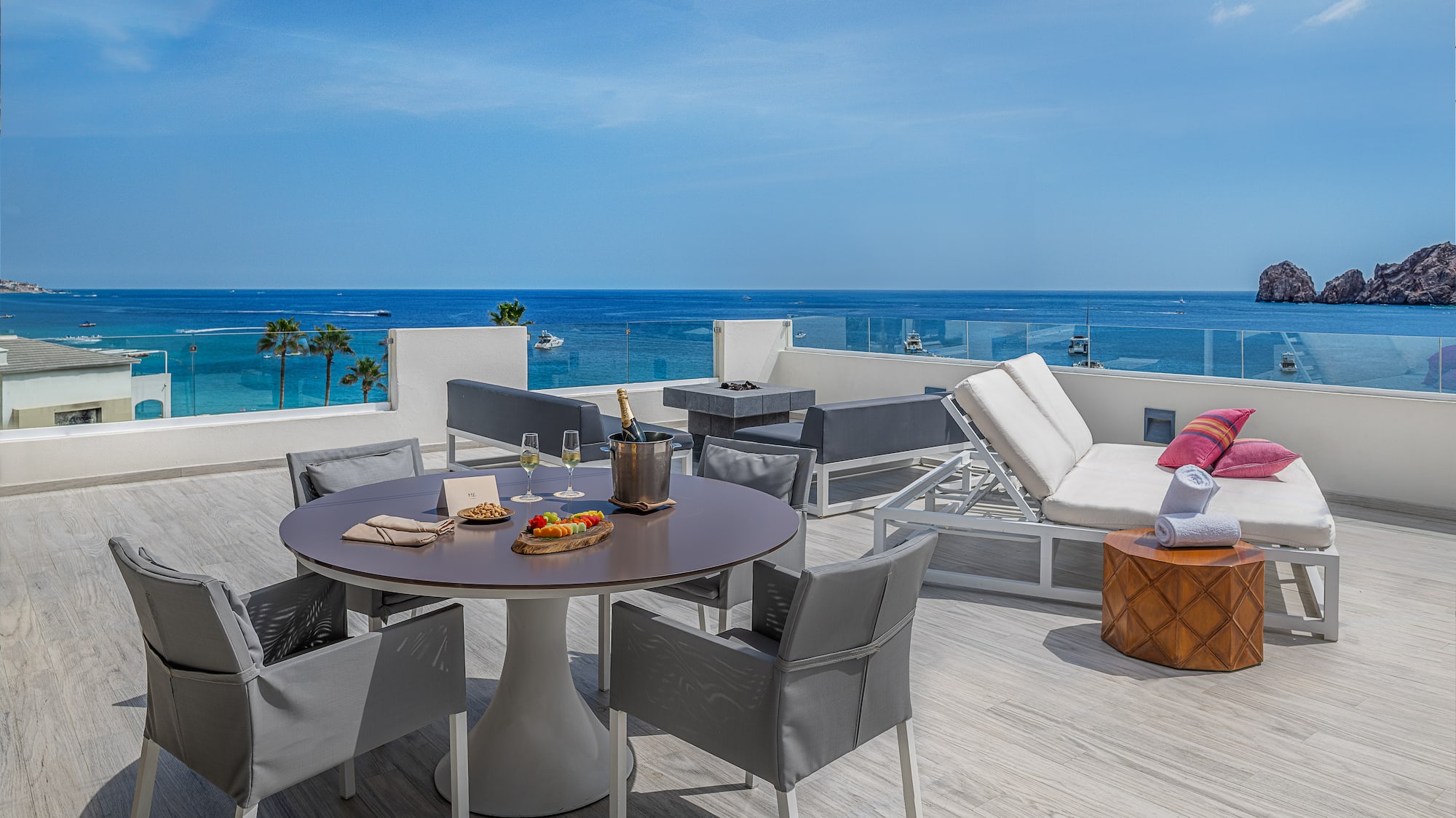 a table and chairs on a deck overlooking the ocean