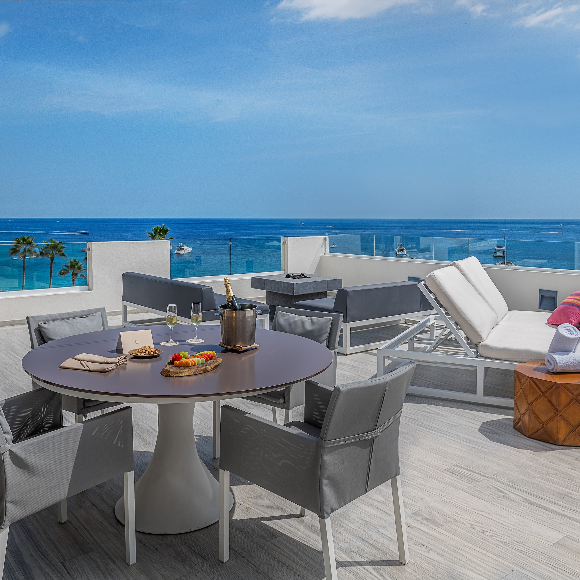 a table and chairs on a deck overlooking the ocean