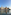 Industrial waterfront: crane, modern and brick buildings, chimney, water reflections.