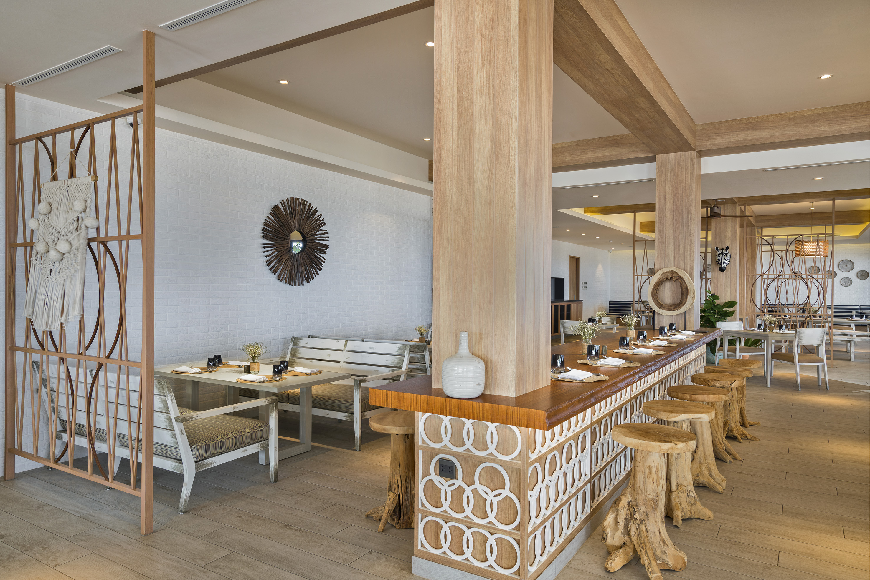 Light wood restaurant interior with unique root bar stools and dining tables.