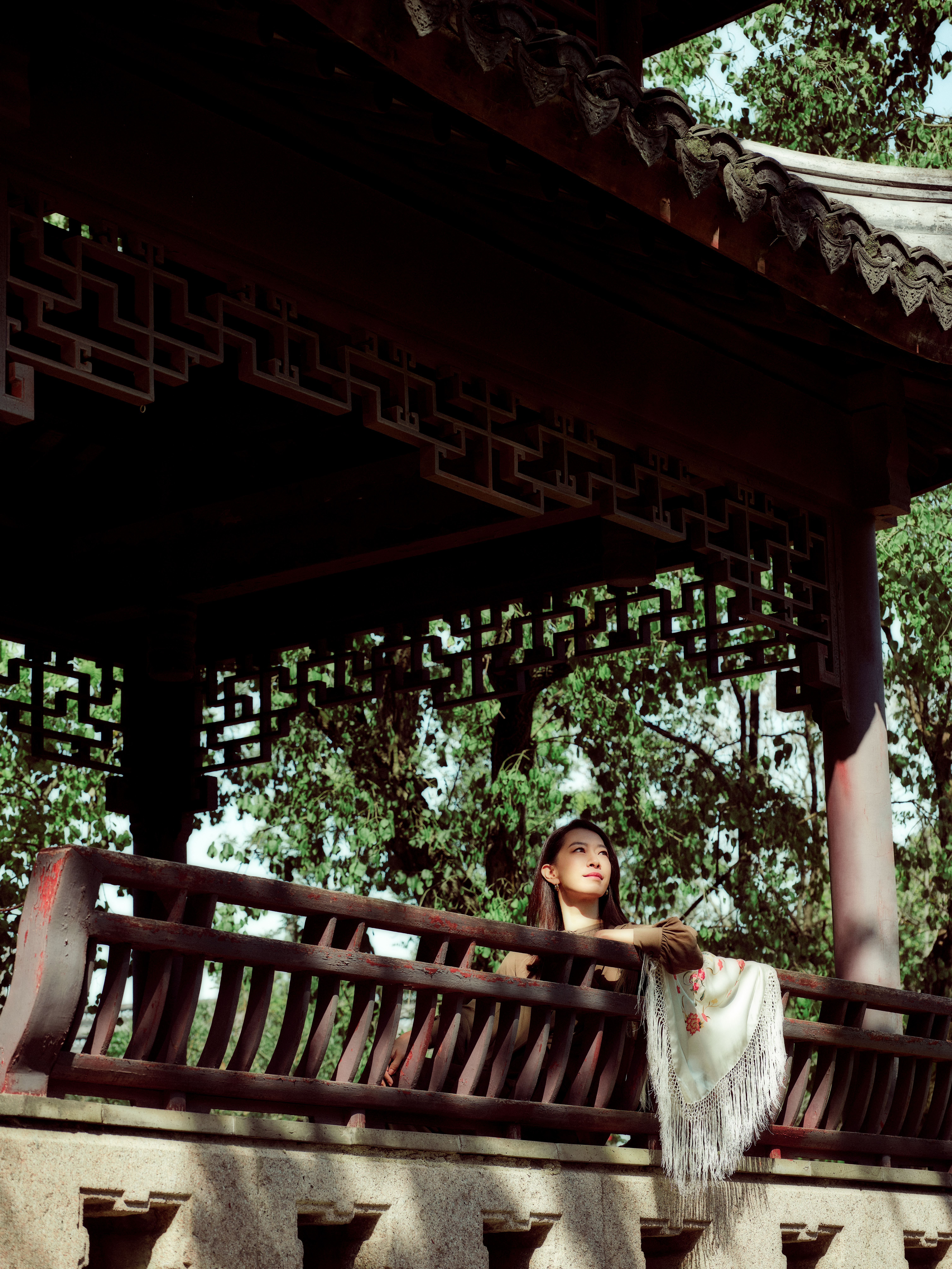 a woman sitting on a bench under a gazebo