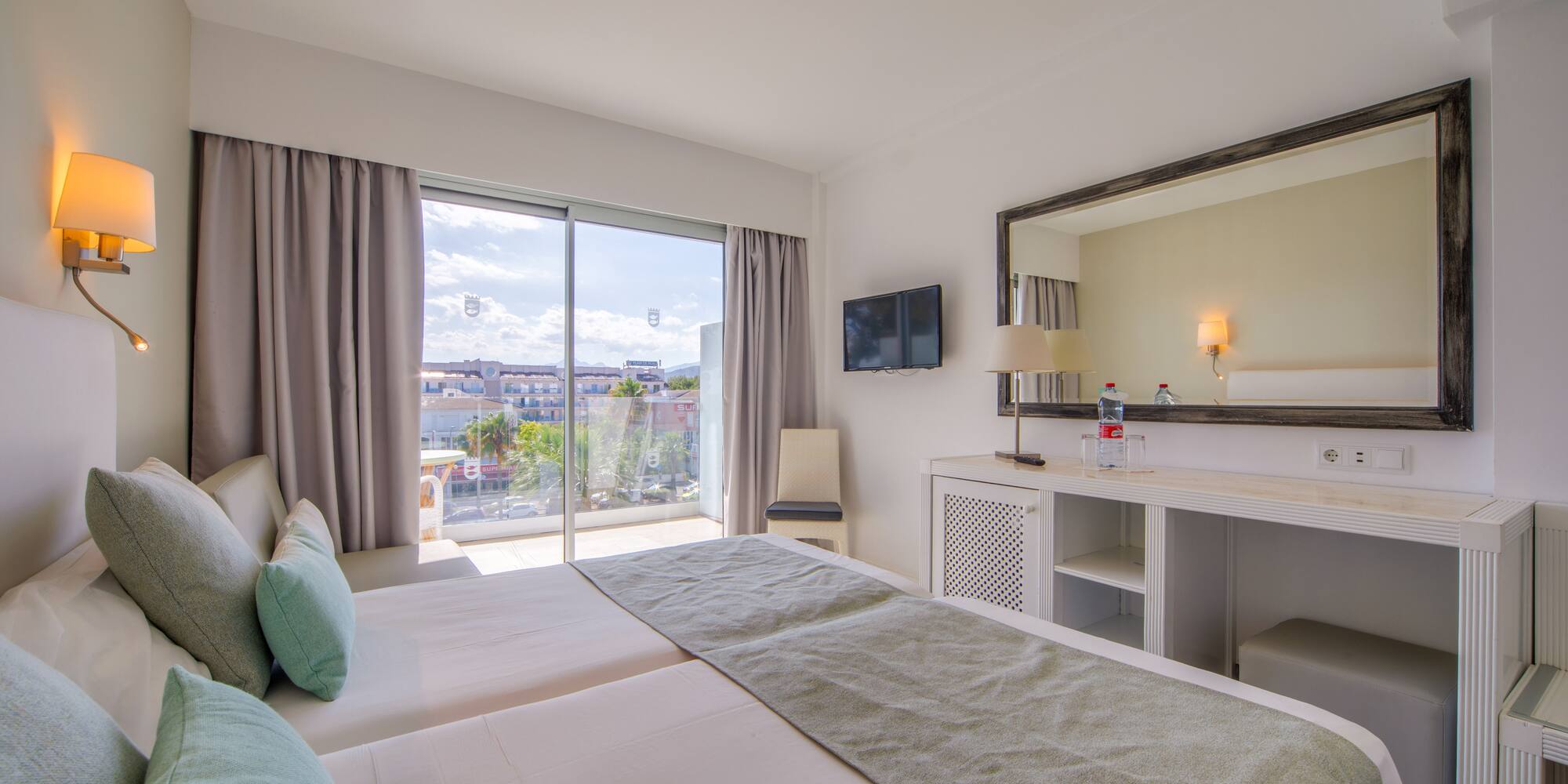 a bedroom with a large mirror and a large bed