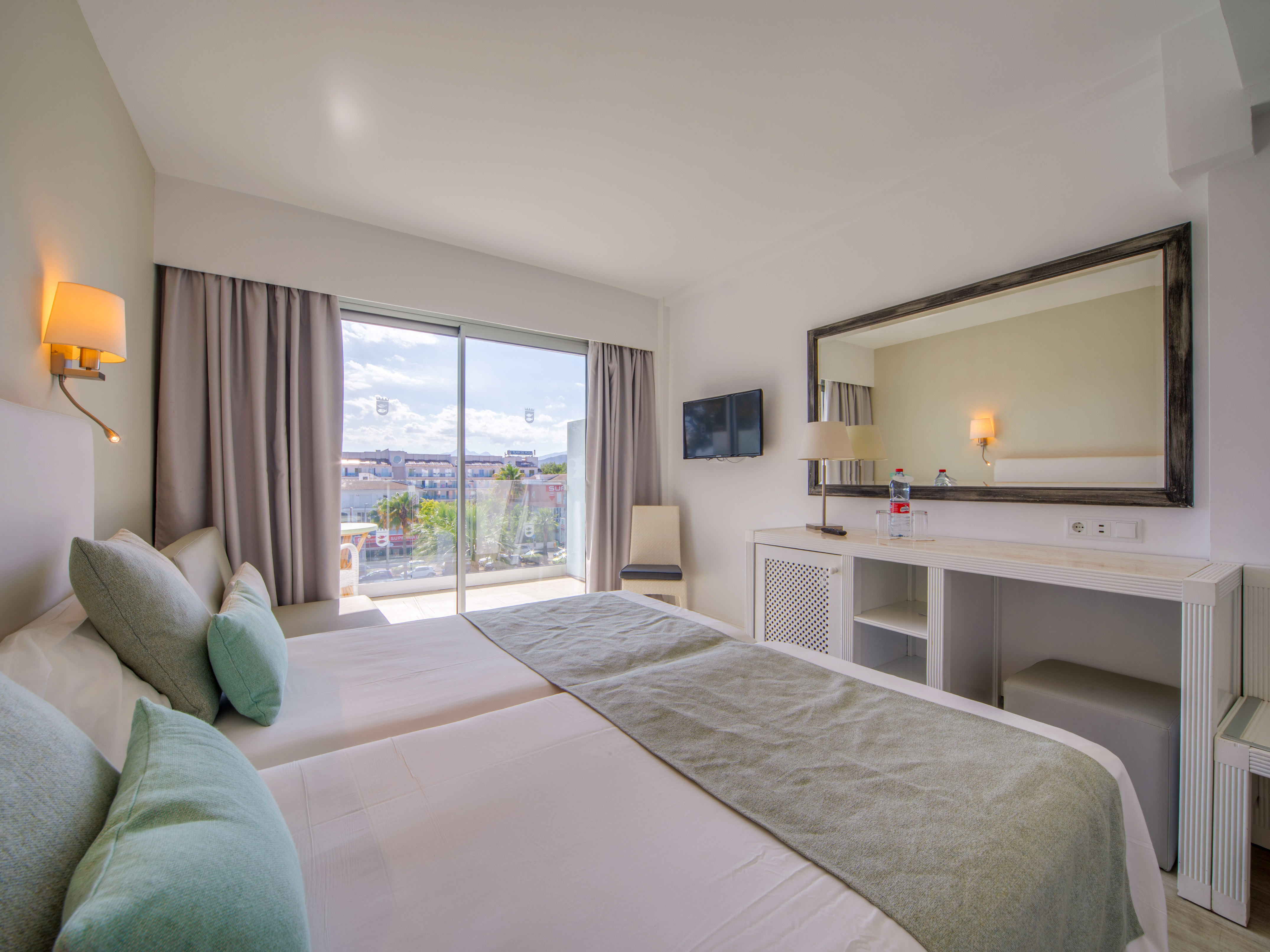 a bedroom with a large mirror and a large bed