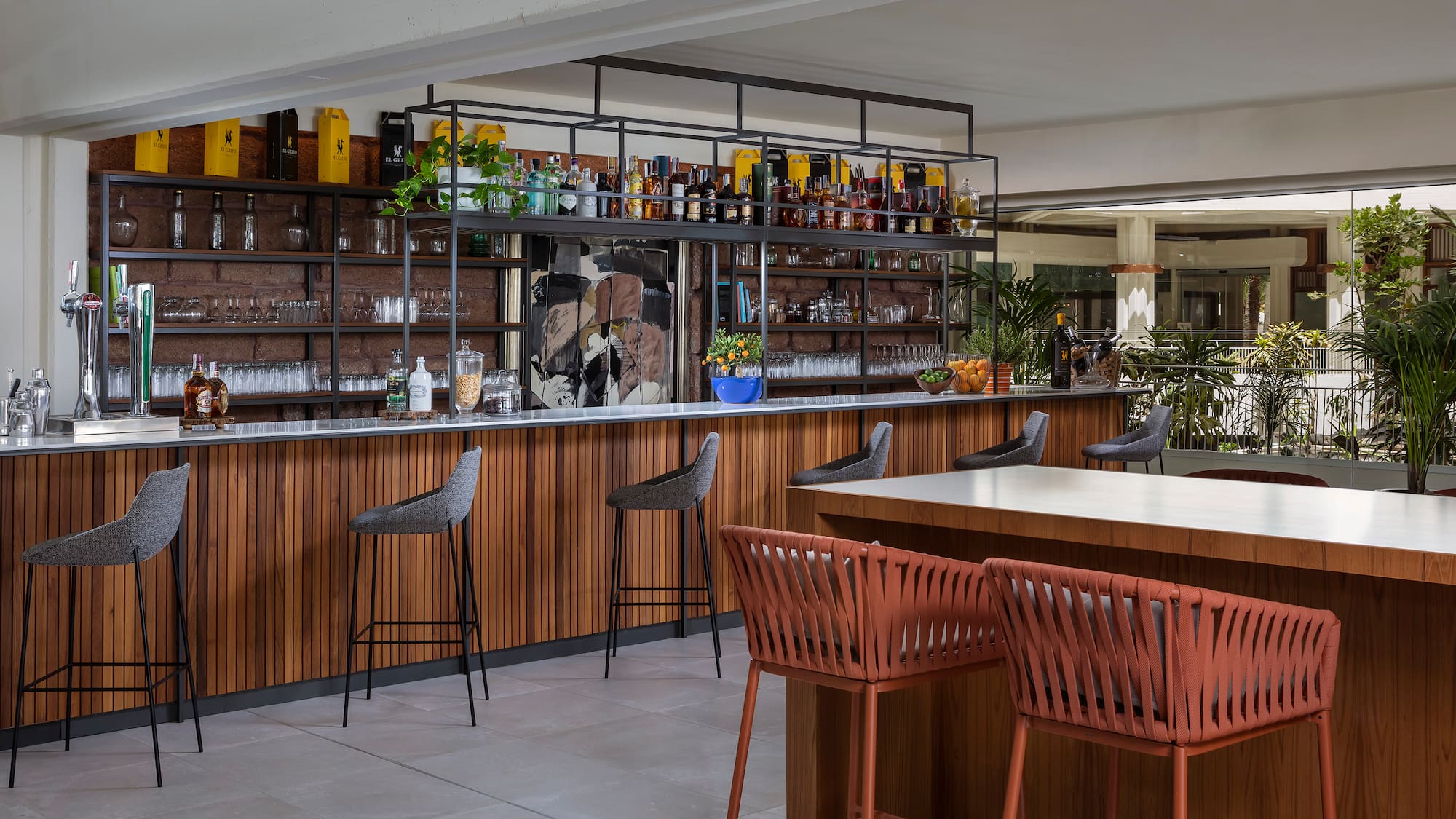 a bar with chairs and a shelf with bottles