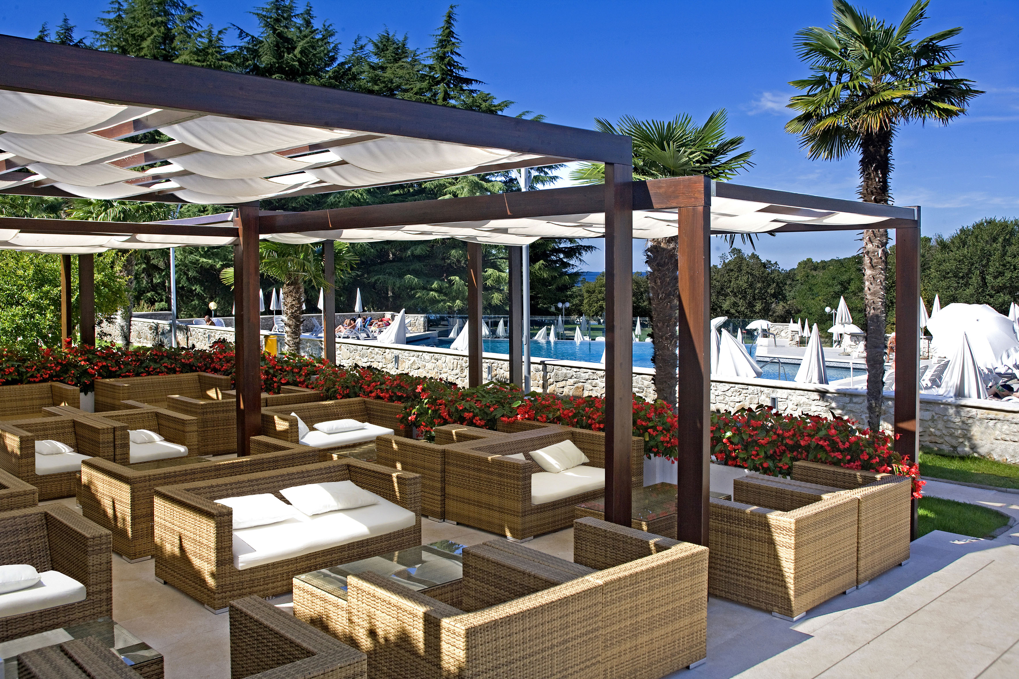 a patio with wicker furniture and a pool of water