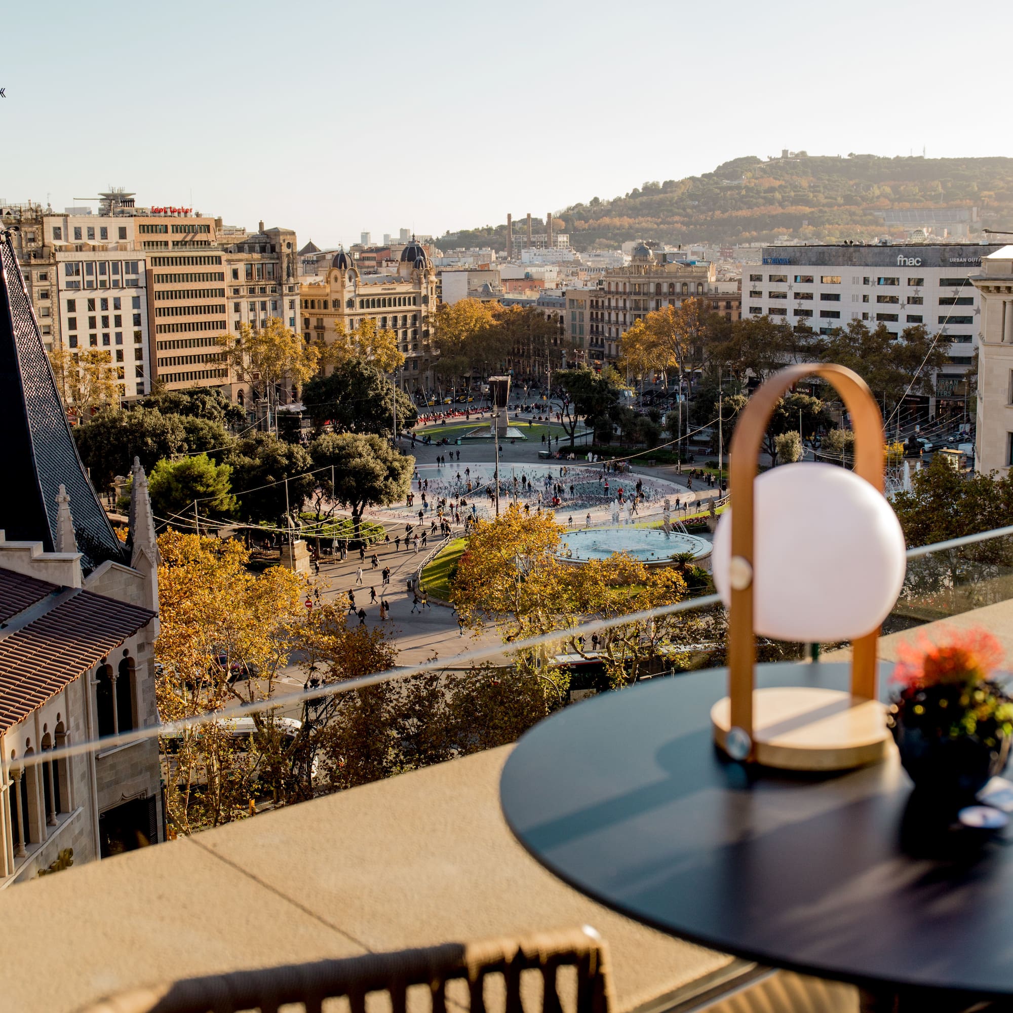 Cityscape from rooftop, Barcelona's Plaça de Catalunya fountain & fall foliage.