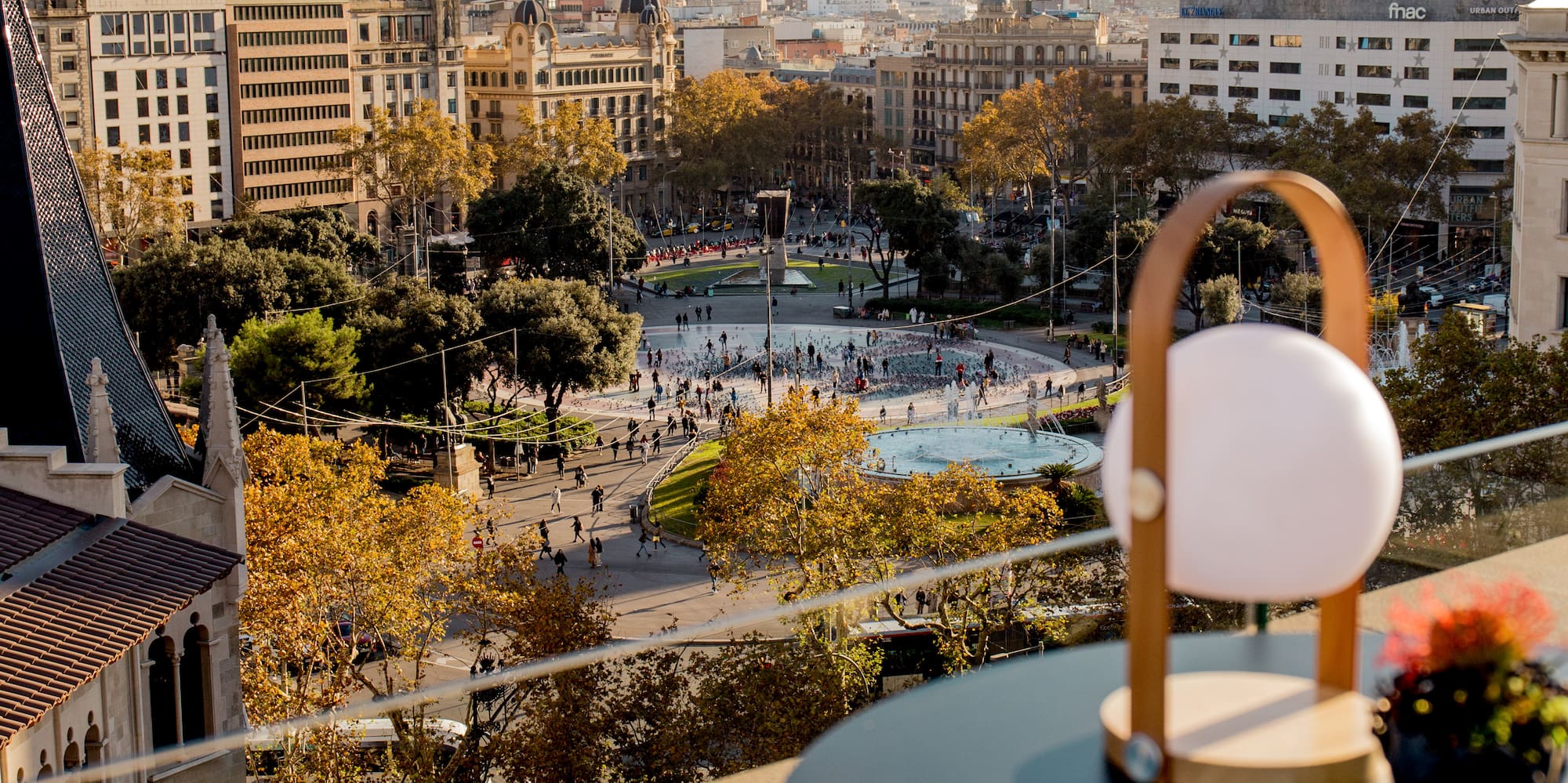 Cityscape from rooftop, Barcelona's Plaça de Catalunya fountain & fall foliage.