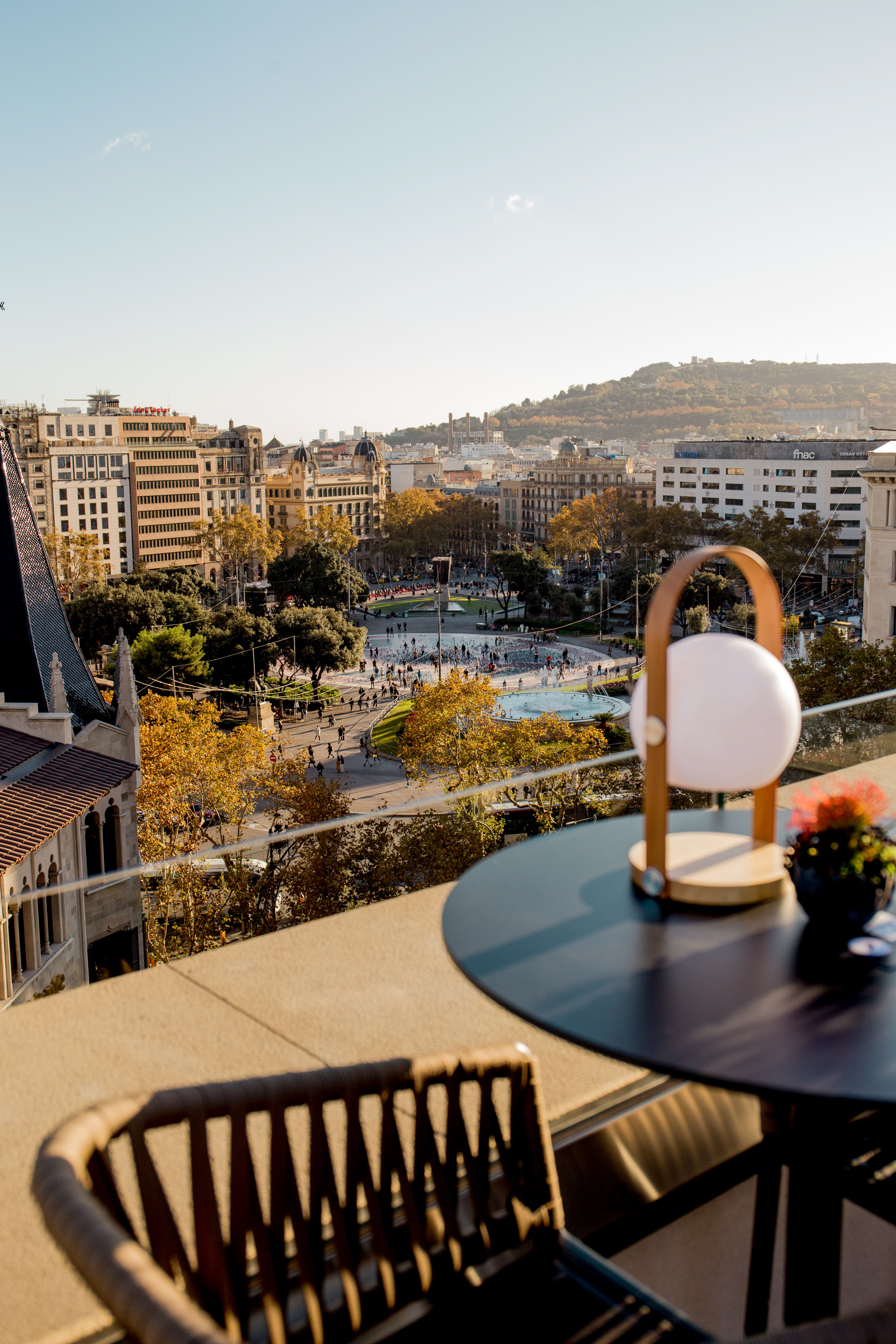 Cityscape from rooftop, Barcelona's Plaça de Catalunya fountain & fall foliage.