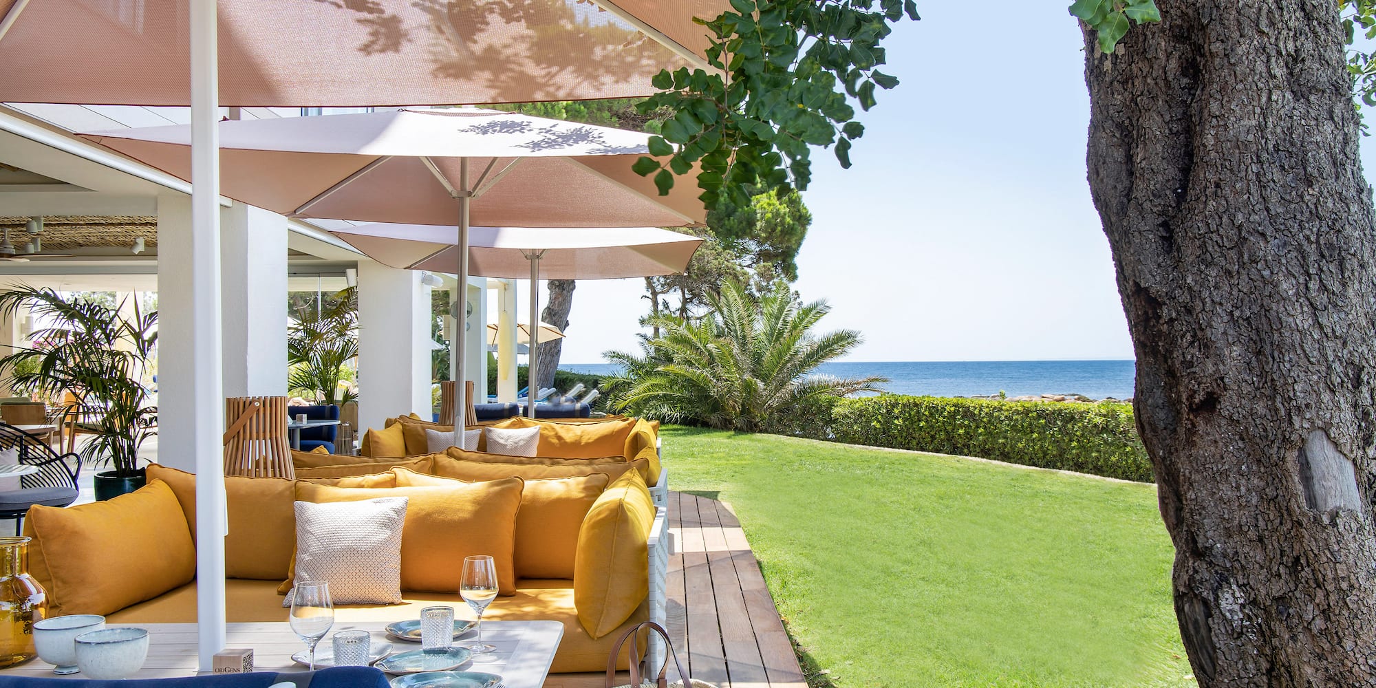 a patio with a table and chairs and umbrellas.