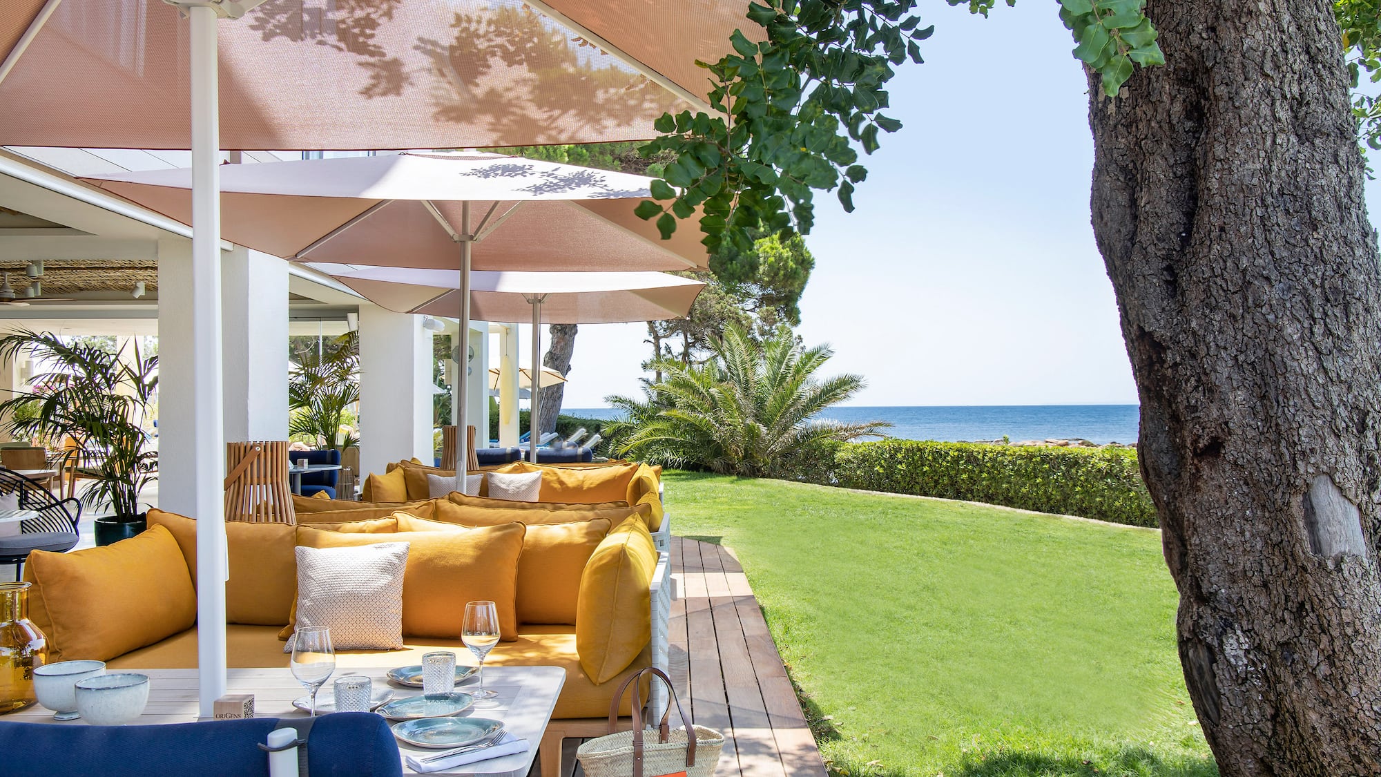 a patio with a table and chairs and umbrellas.