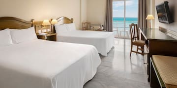 a room with two beds and a table and chairs