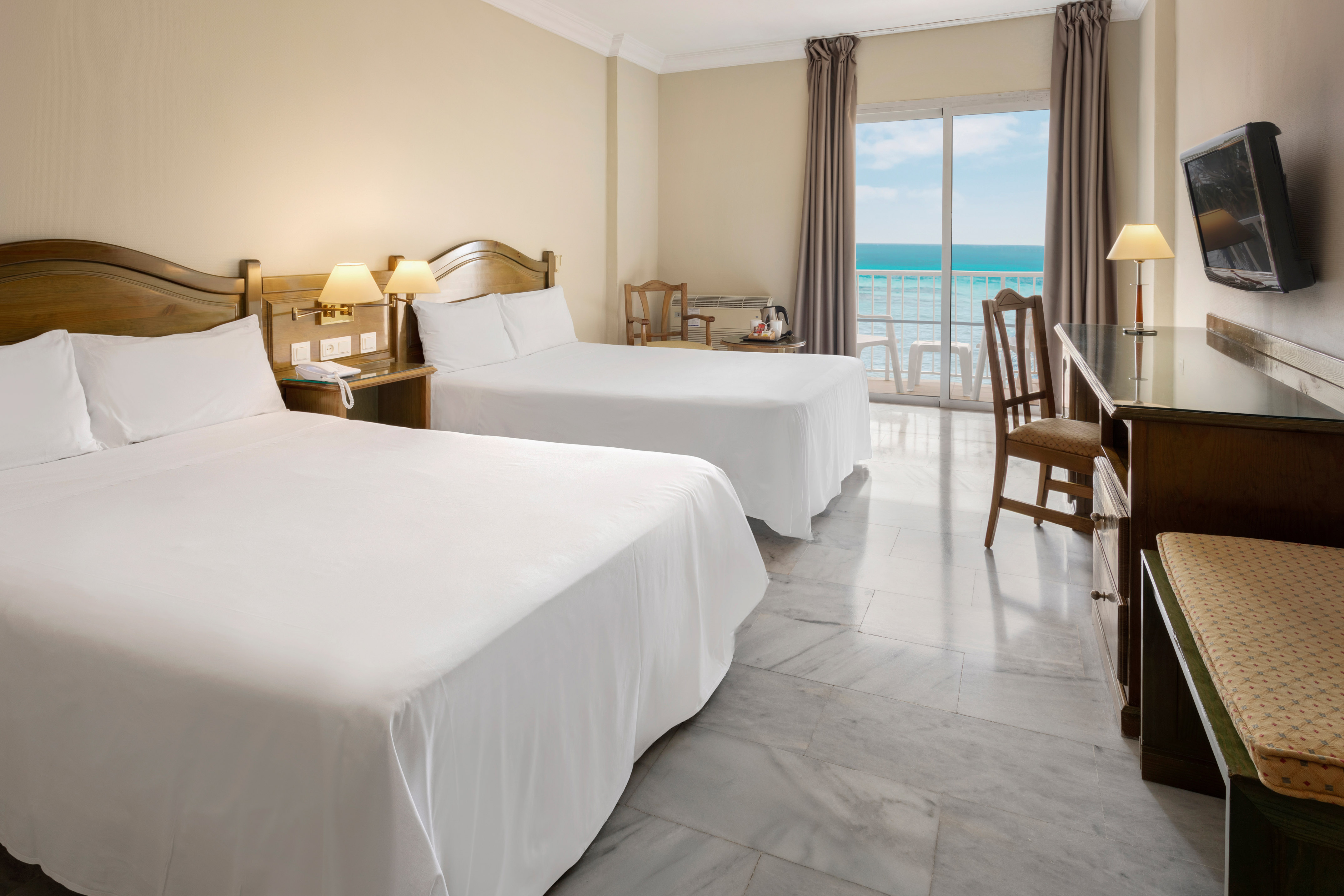 a room with two beds and a table and chairs