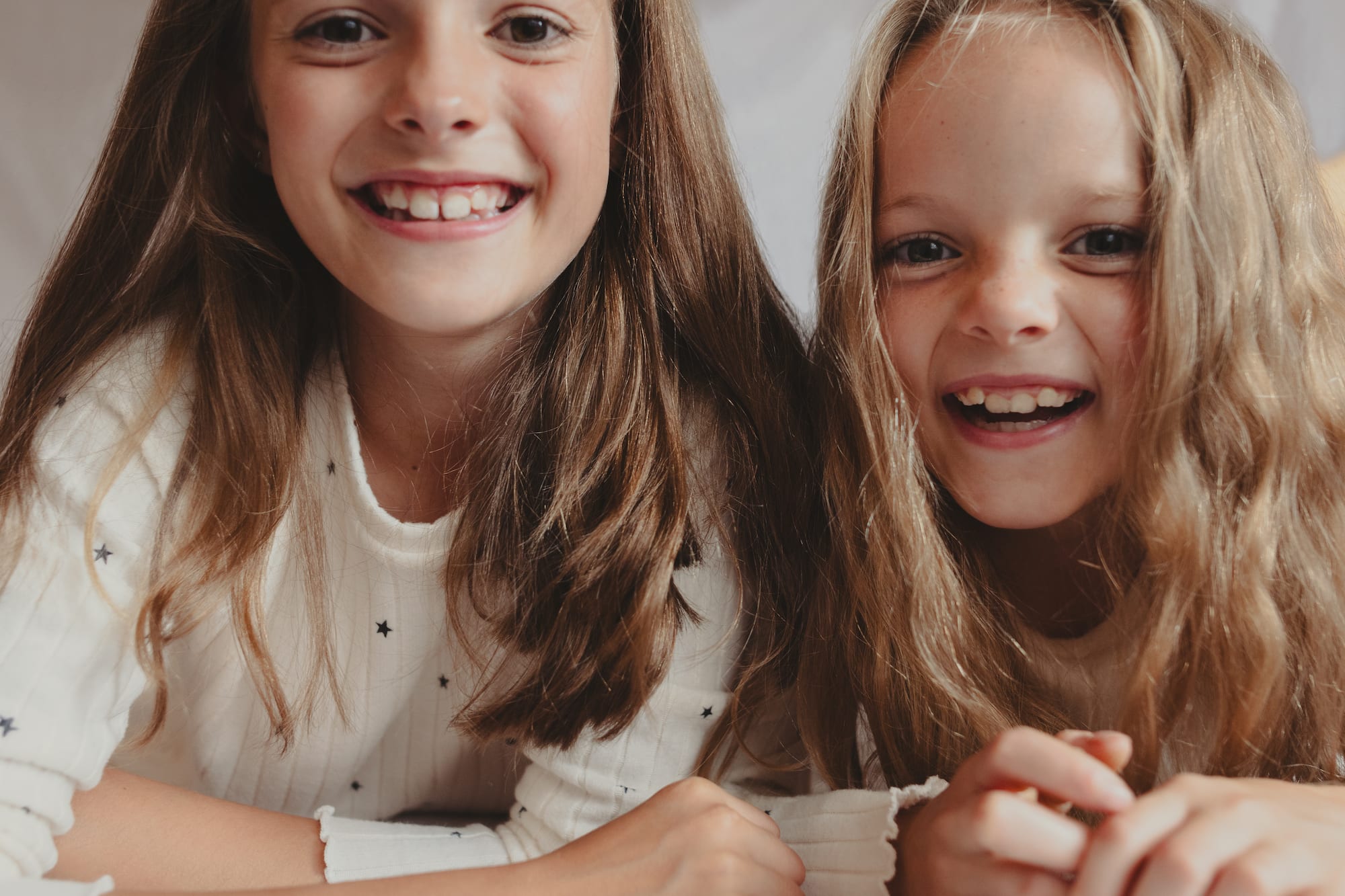two girls lying on a bed