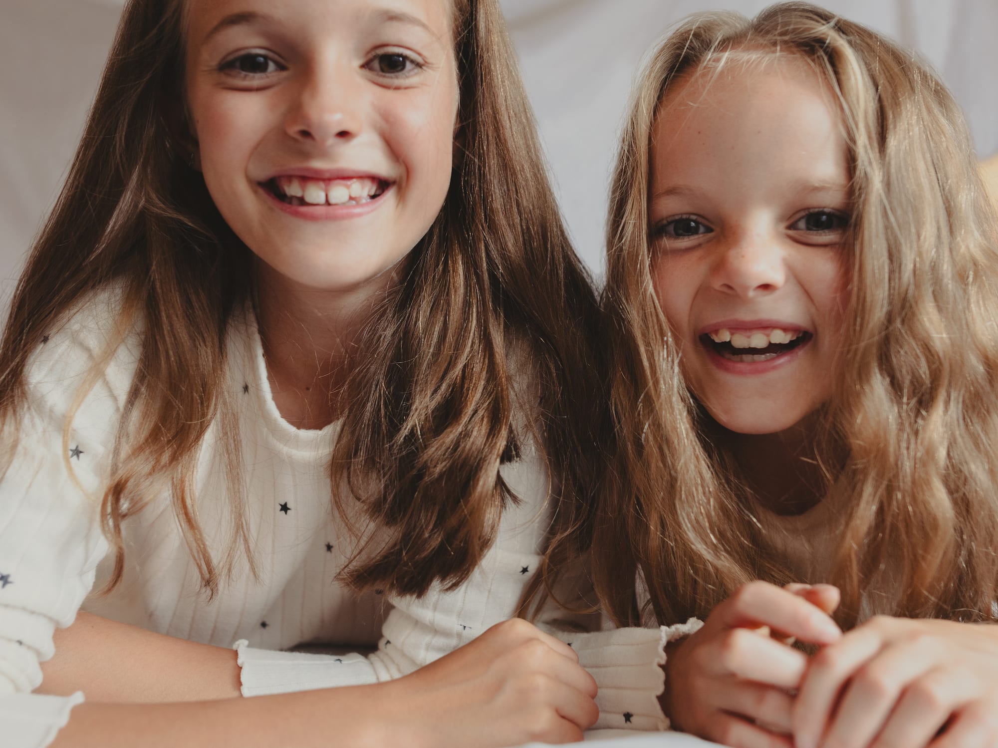 two girls lying on a bed