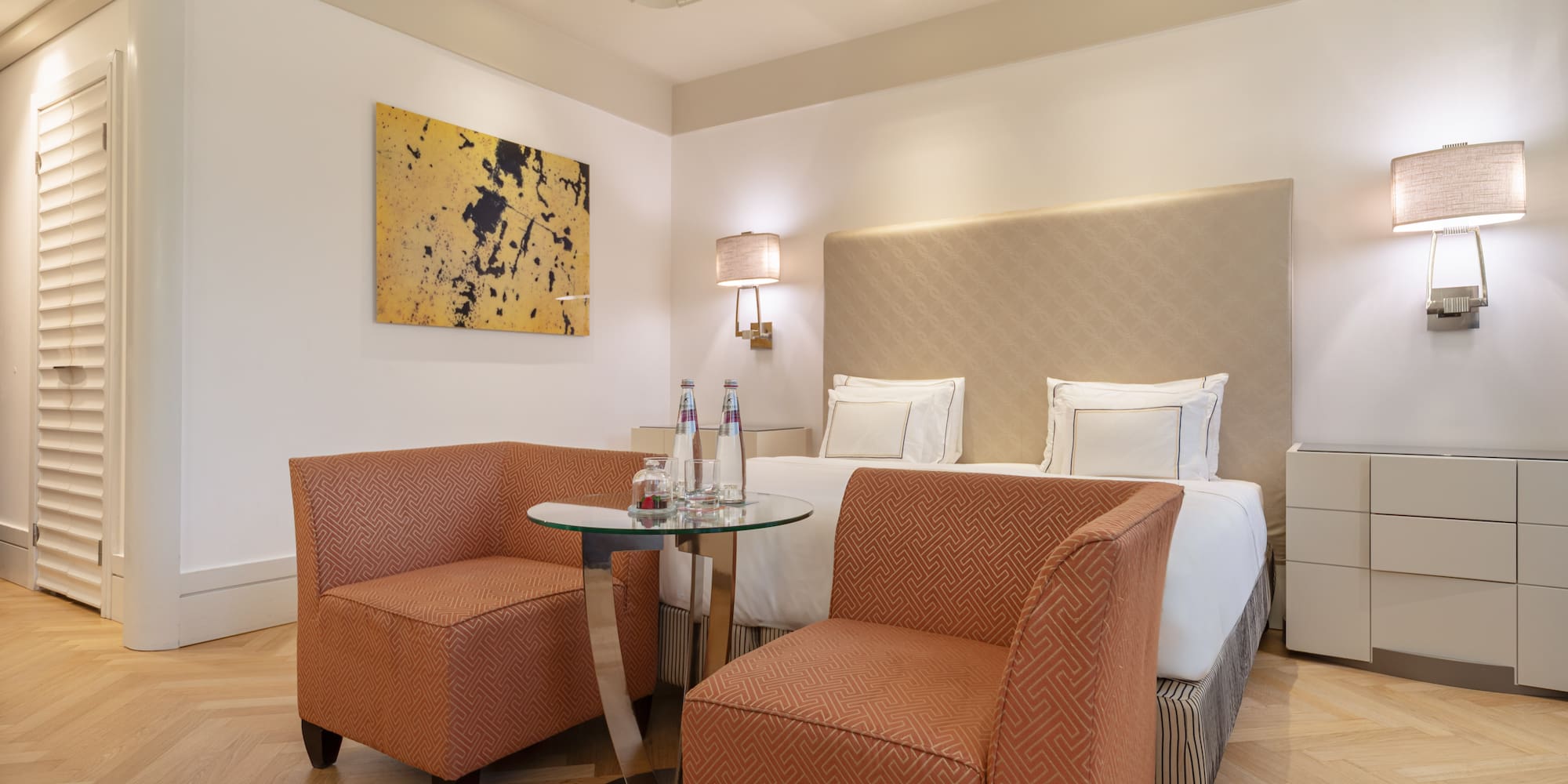 a room with a bed and two chairs