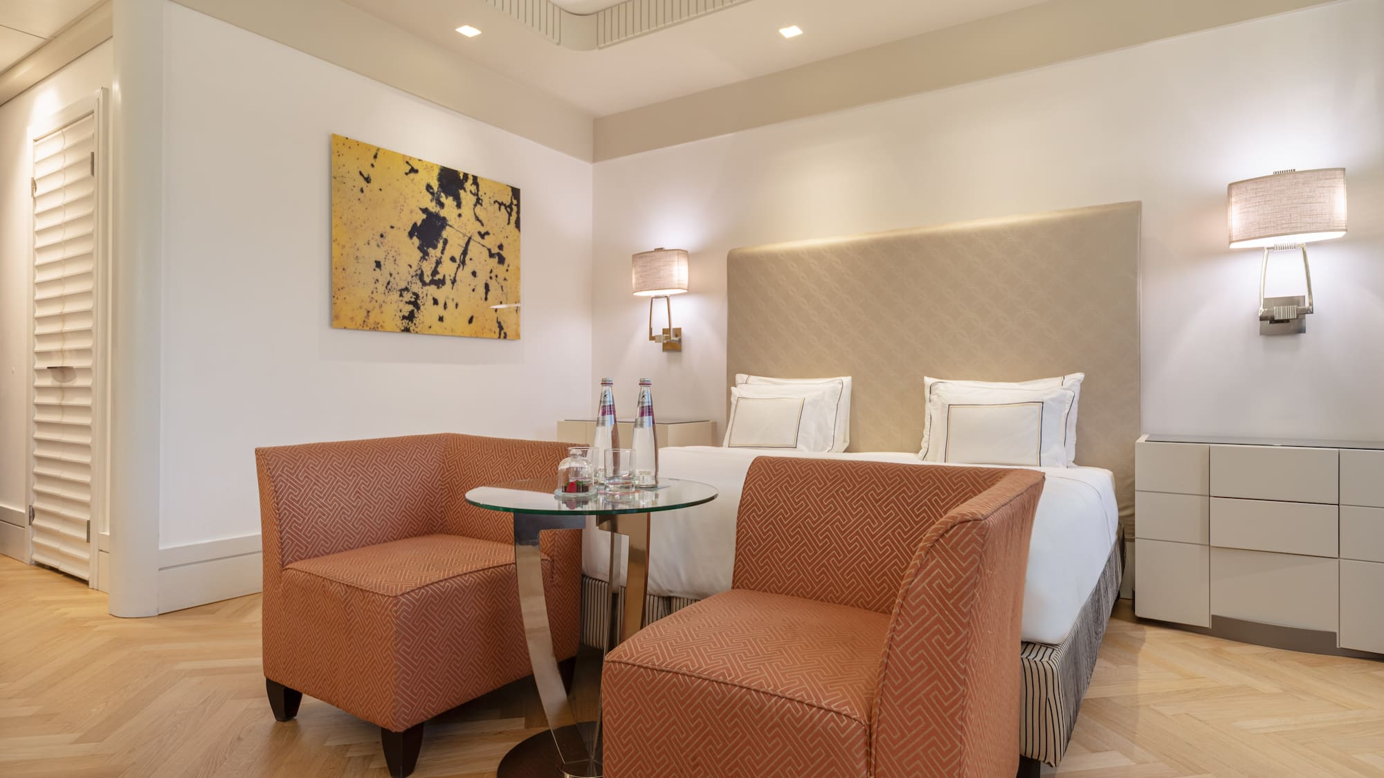 a room with a bed and two chairs