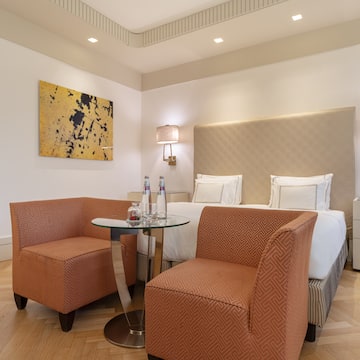 a room with a bed and two chairs