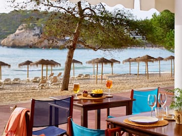 a table and chairs on a beach