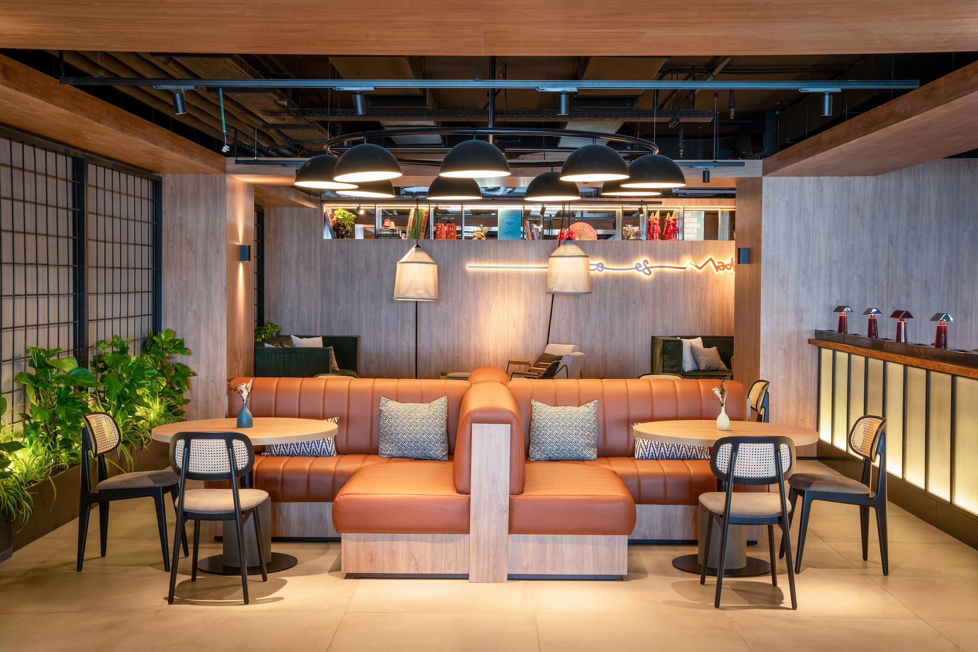 Modern lounge with brown leather booth seating, wood accents, and ambient lighting.
