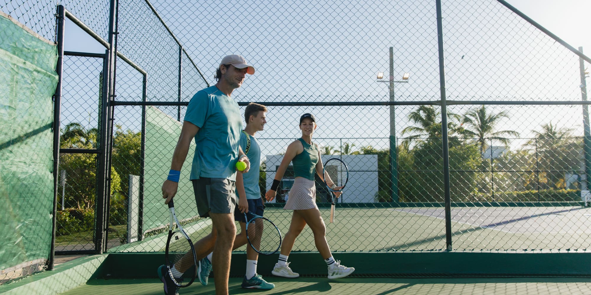 a group of people walking on a tennis court