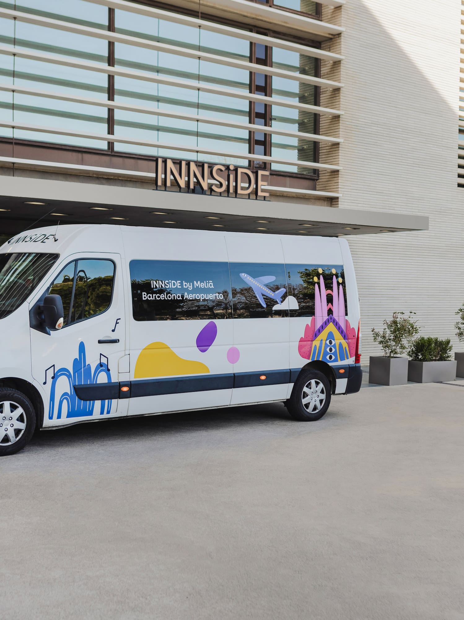a white van with colorful designs in front of a building.