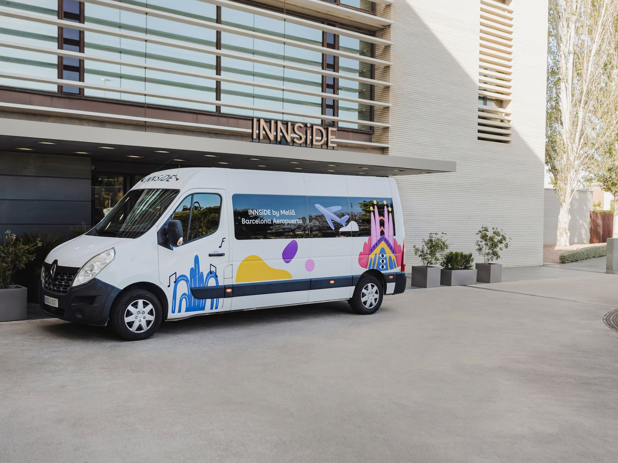 a white van with colorful designs in front of a building.