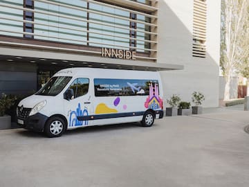a white van with colorful designs in front of a building.