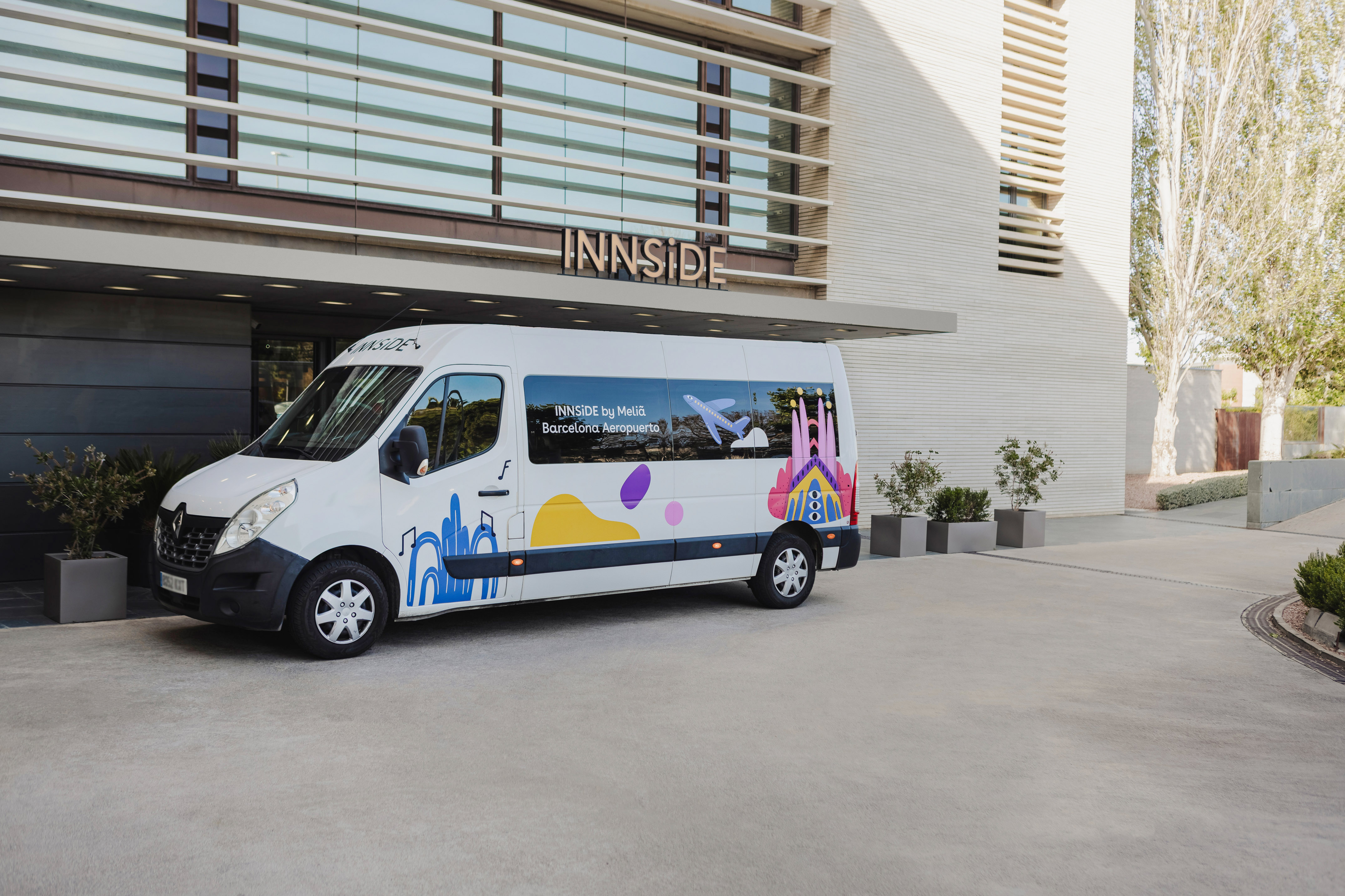 a white van with colorful designs in front of a building.